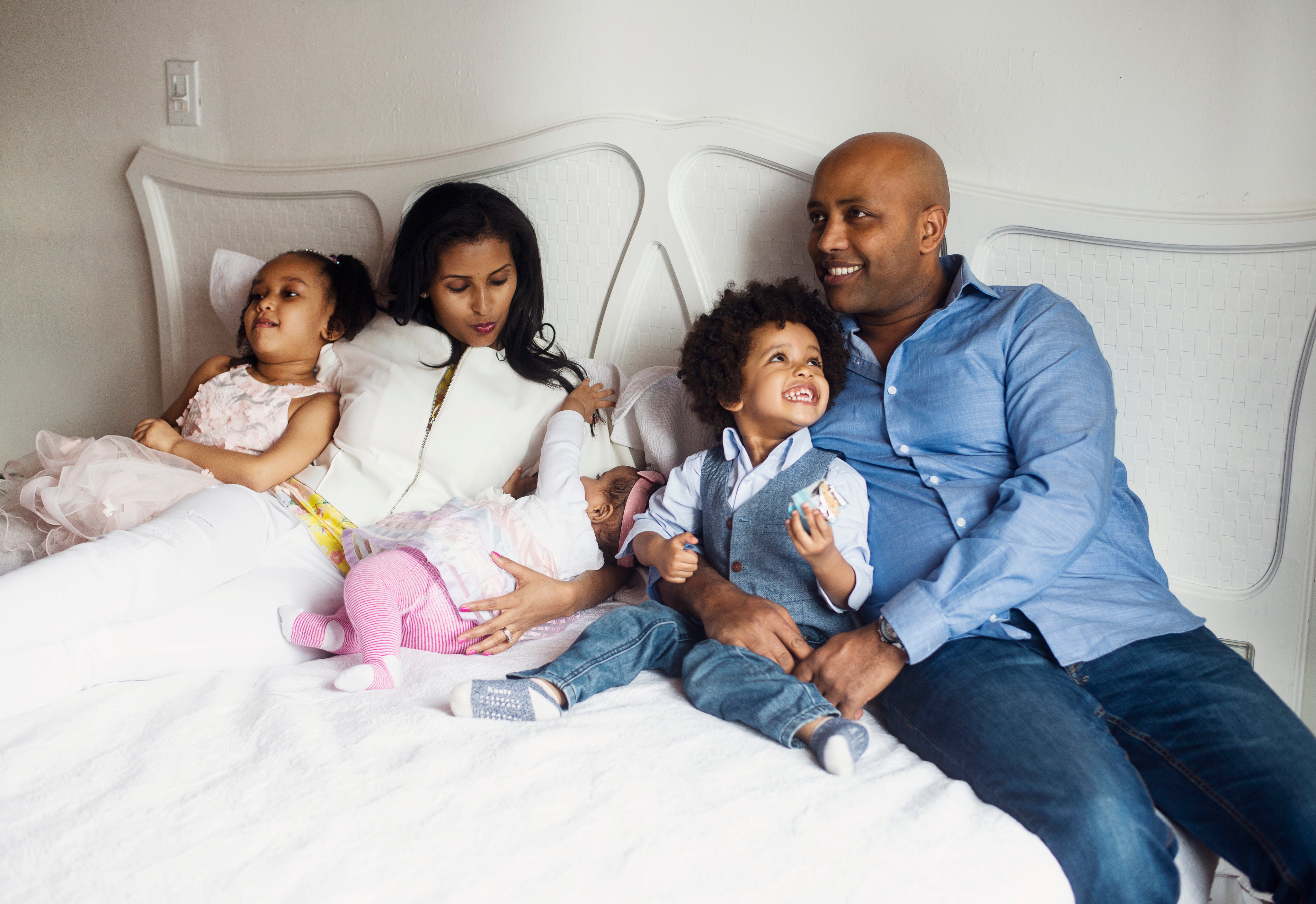 eine glückliche Familie liegt zusammen im Bett